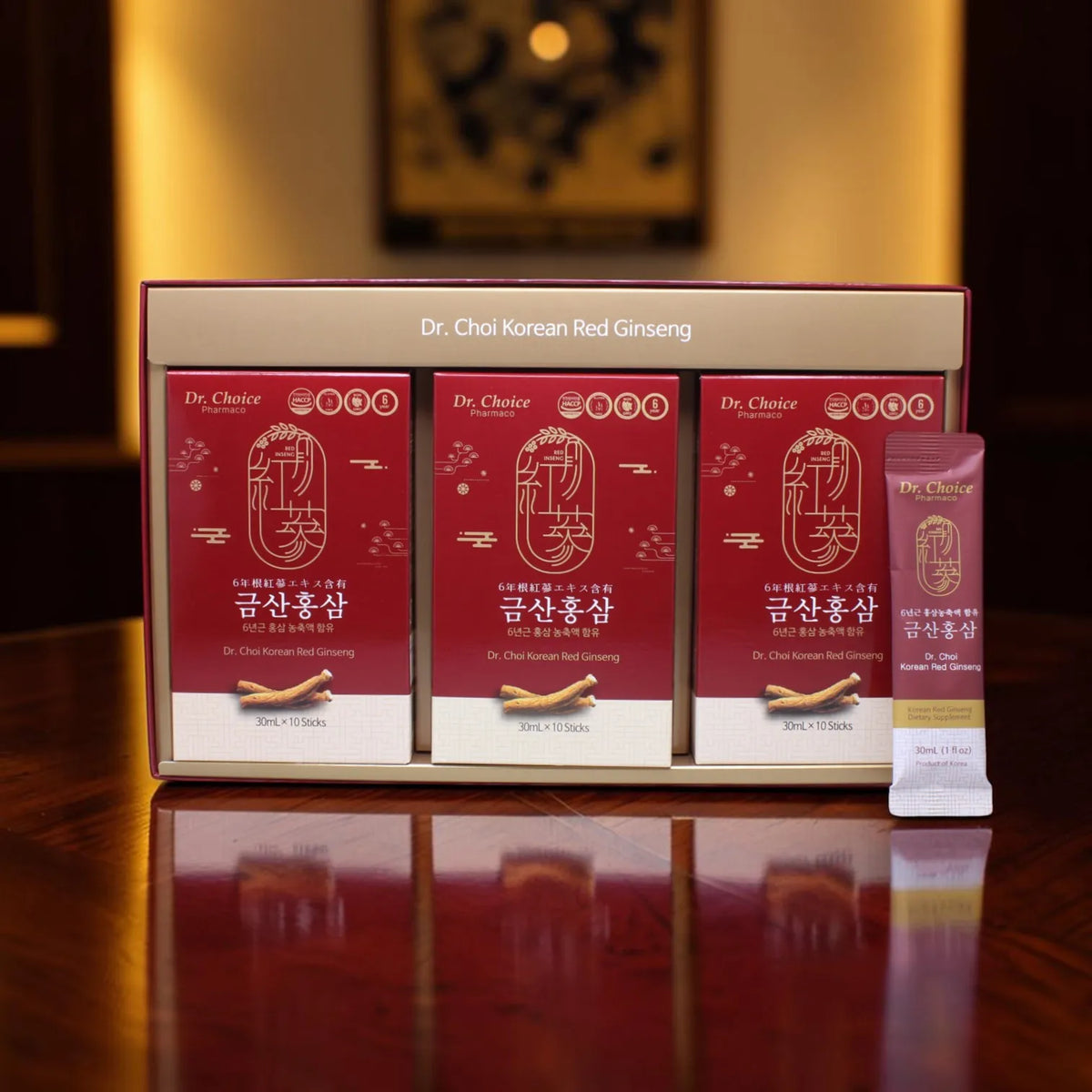 Open Dr. Choi Korean Red Ginseng gift box: a gold tray holding three red inner boxes of 10 sticks, with one single 30 mL stick standing in front.